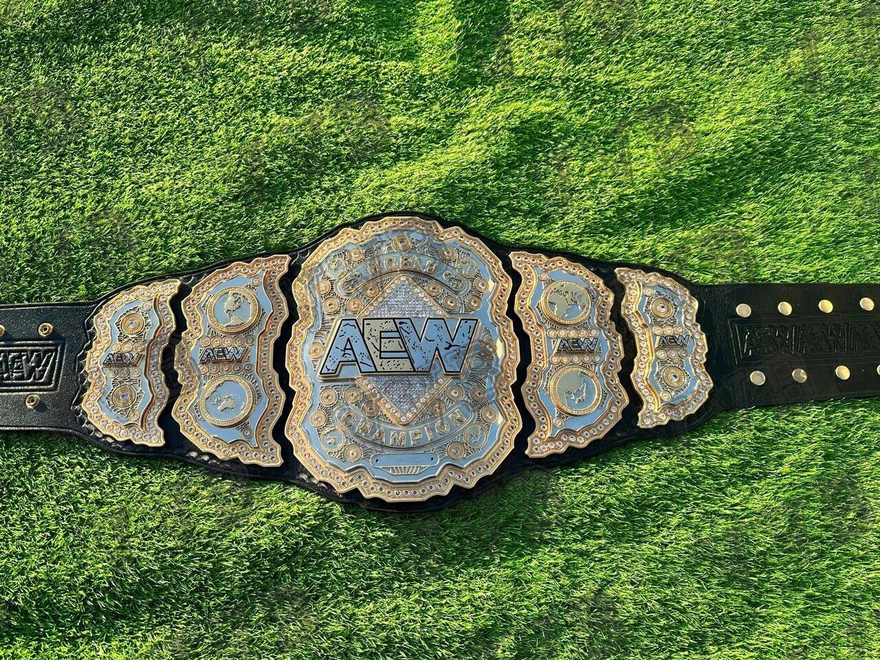 AEW championship belt on a grassy background